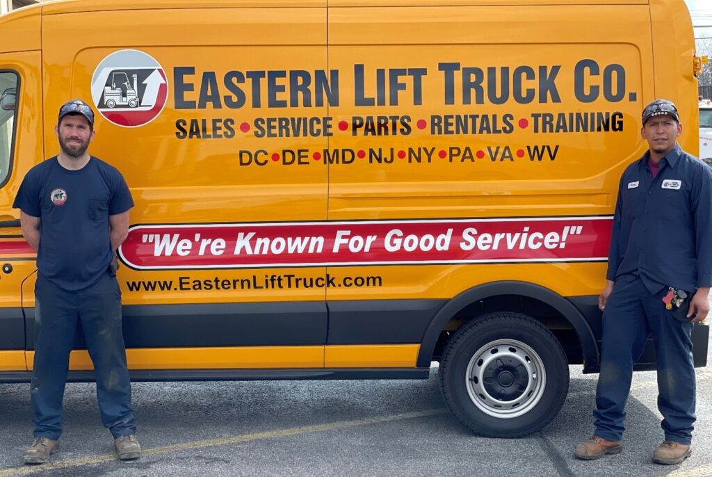 Two Eastern Lift Truck Co. Technicians standing in front of a service van.