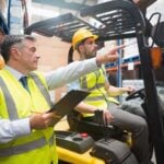Forklift driver talking with his manager during forklift operator training course.