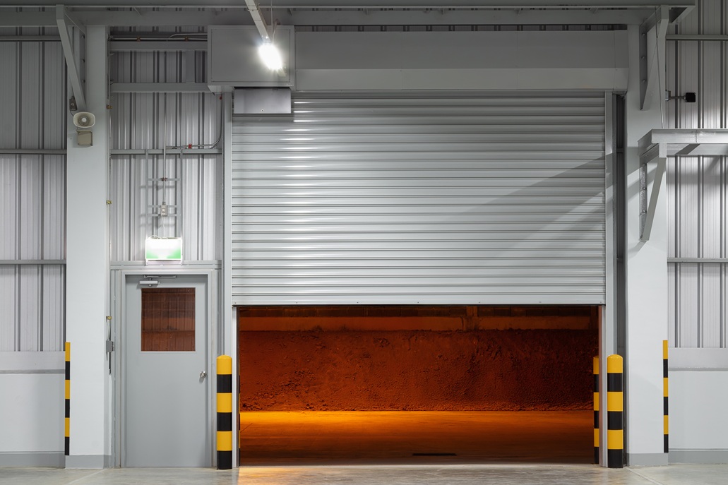Shutter door or roller shutter inside industrial building at fro Overhead Door that is partially open.