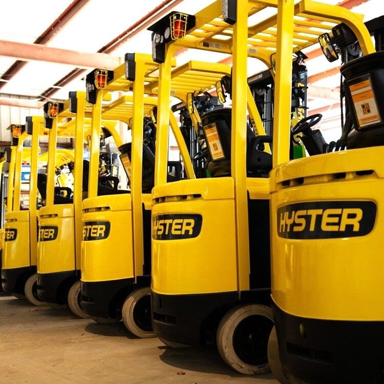 Fleet of new Hyster forklifts in a row.